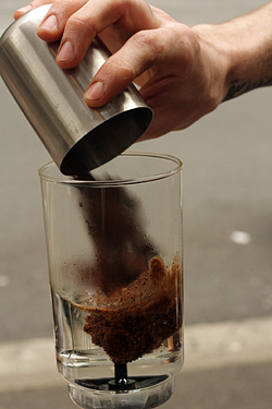 adding coffee to siphon coffee
